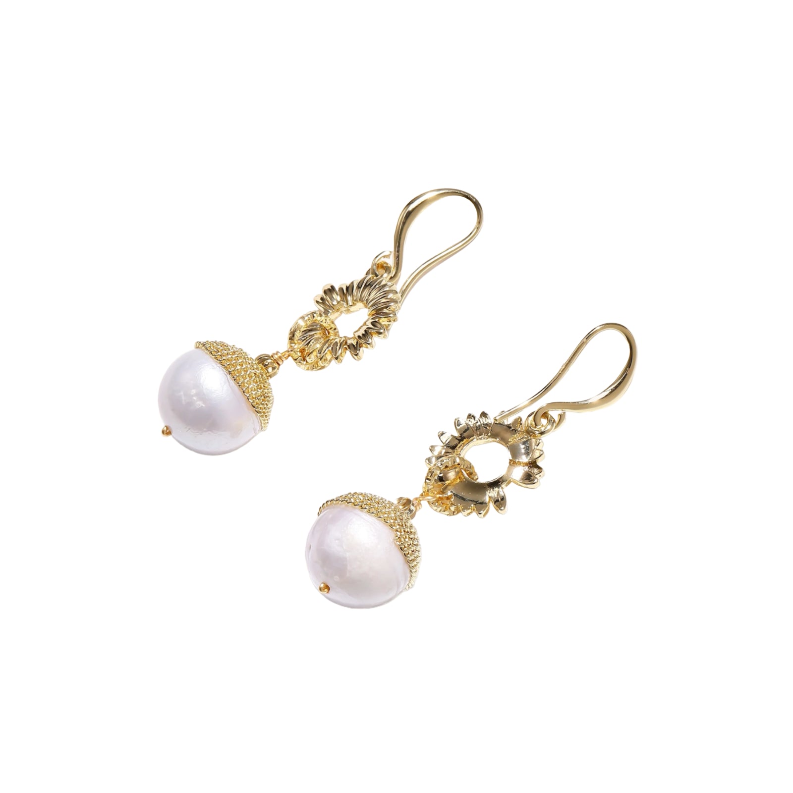 Gold sunburst charm earrings with baroque pearl drops on French hooks against cream background