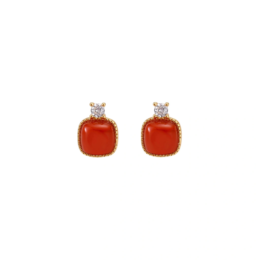 18K gold vermeil stud earrings with cushion-cut red agate stones and sparkling crystal accents on beige background