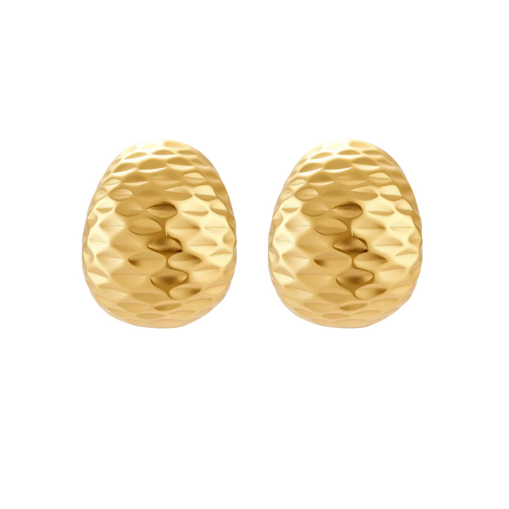 Pair of textured gold-plated sterling silver huggie earrings with dimpled surface finish on cream background.
