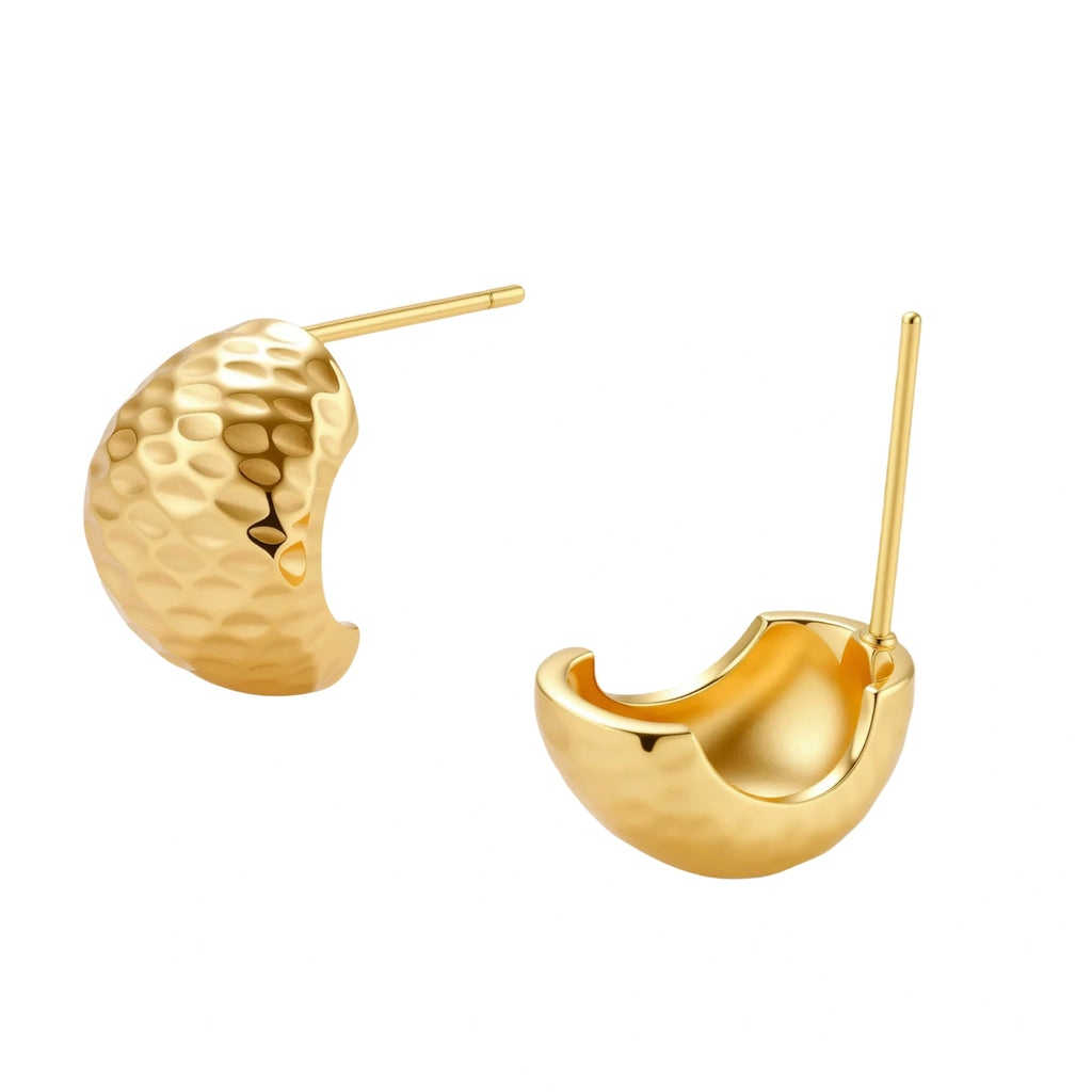 Pair of textured gold-plated sterling silver huggie earrings with dimpled surface finish on cream background.