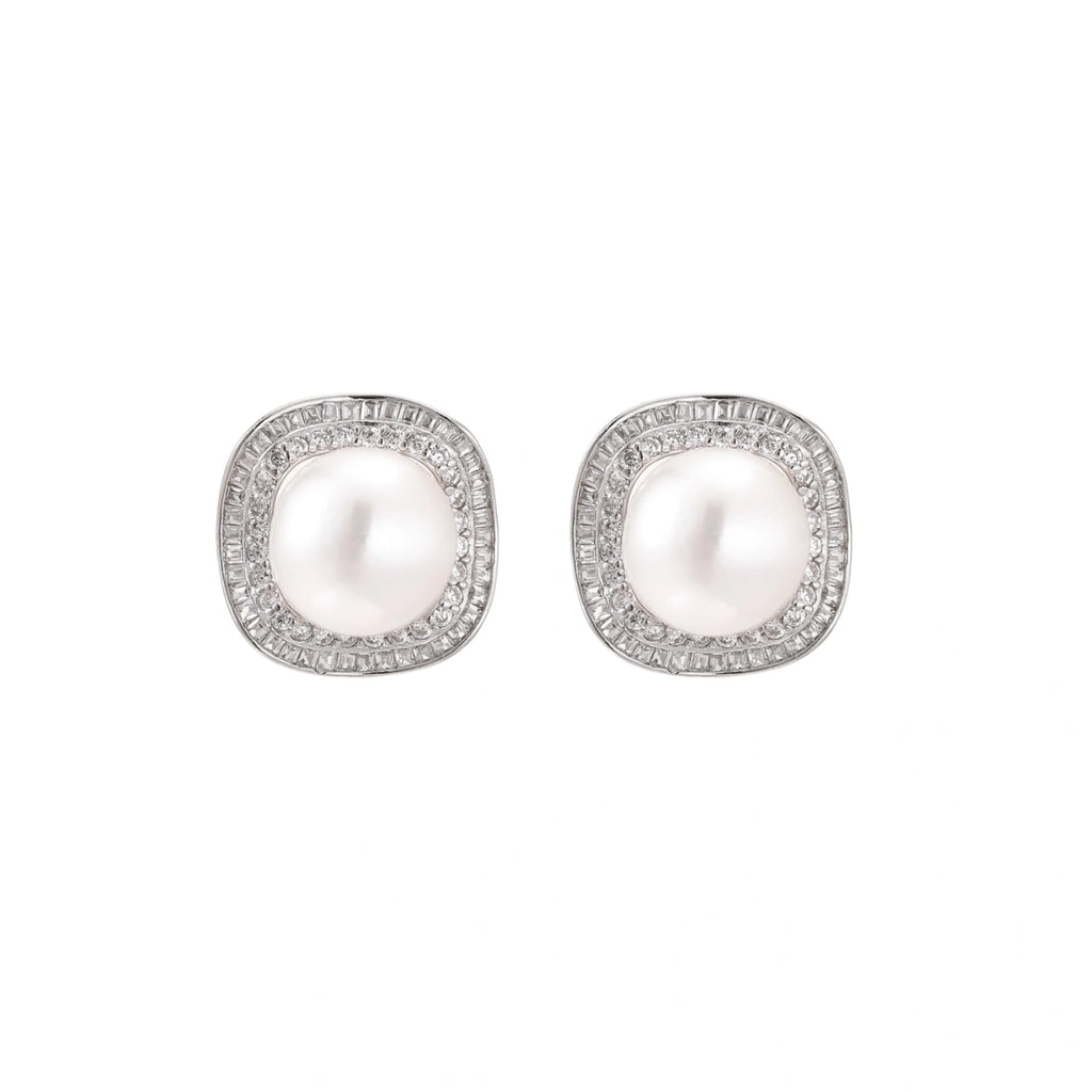 Rhodium-plated sterling silver stud earrings with round freshwater pearls surrounded by geometric crystal halos on cream background.