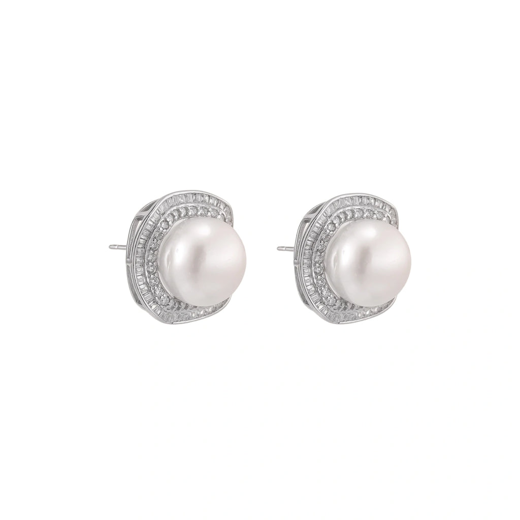 Rhodium-plated sterling silver stud earrings with round freshwater pearls surrounded by geometric crystal halos on cream background.
