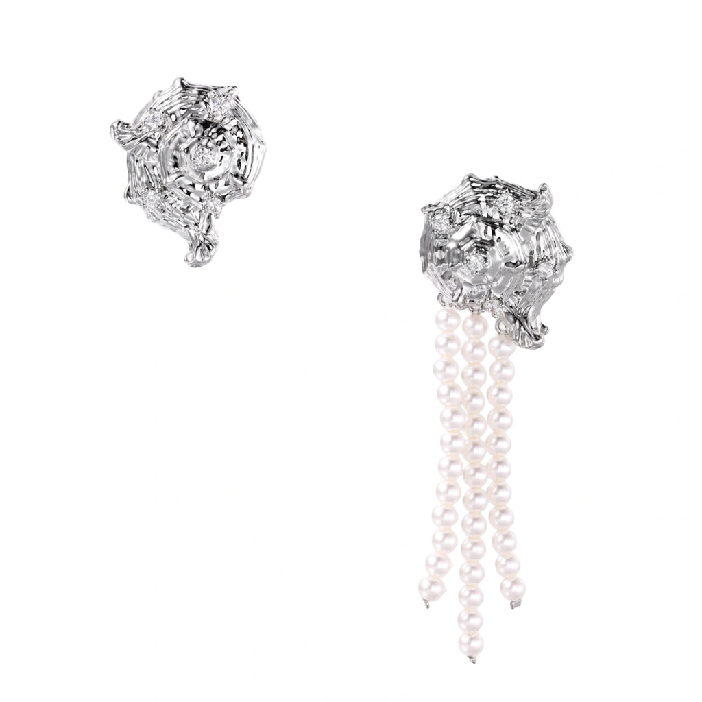 Silver-toned sculptural panther head earrings with zirconia details and white pearl drops on cream background