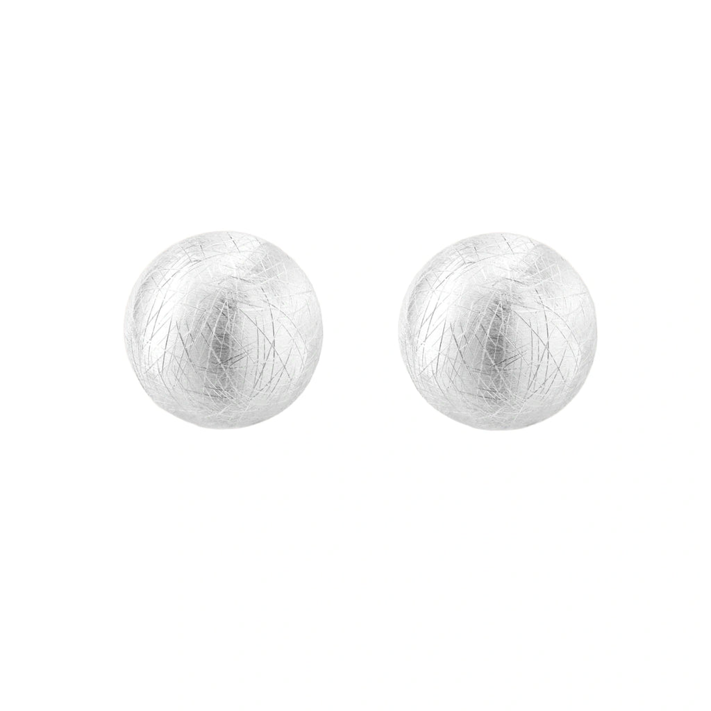 Brushed sterling silver half-dome clip-on earrings with textured surface against cream background