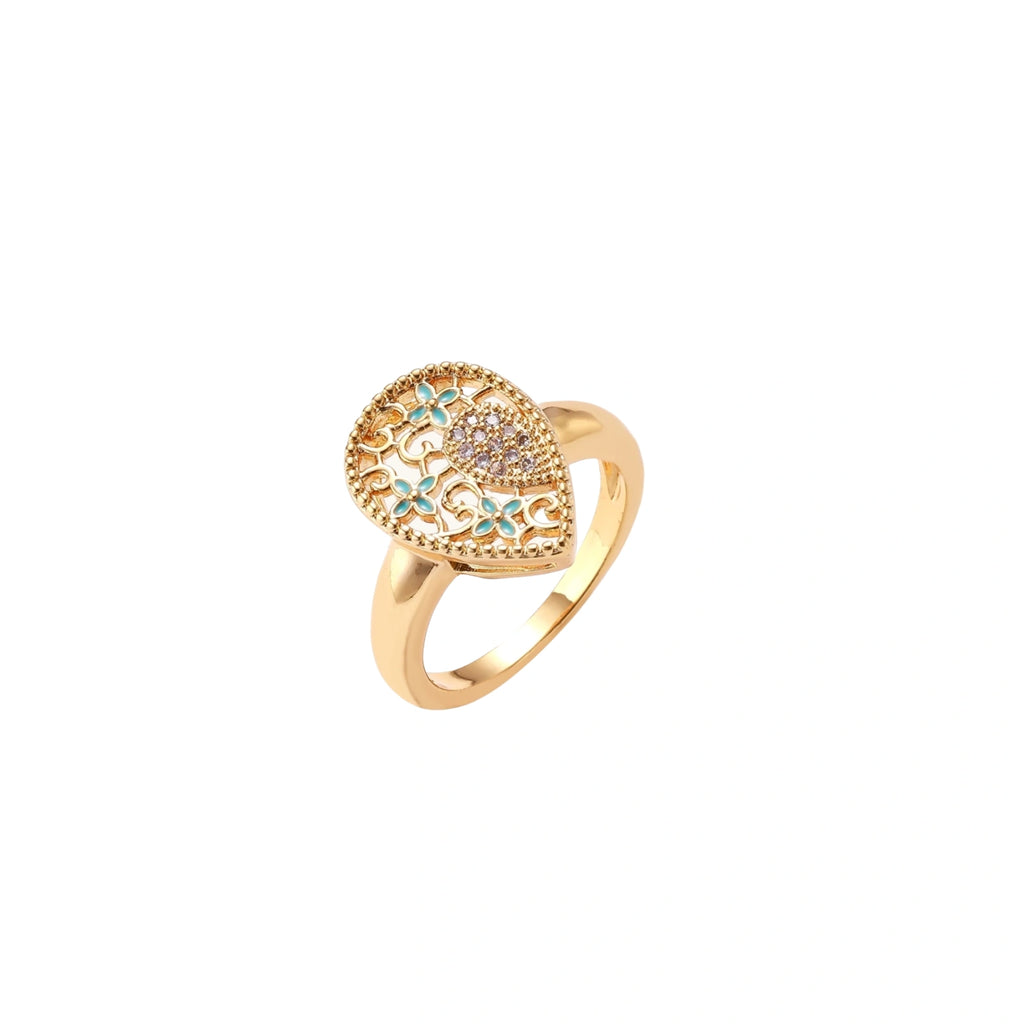 Teardrop-shaped gold-plated ring with turquoise enamel flowers and crystal pavé detail on cream background