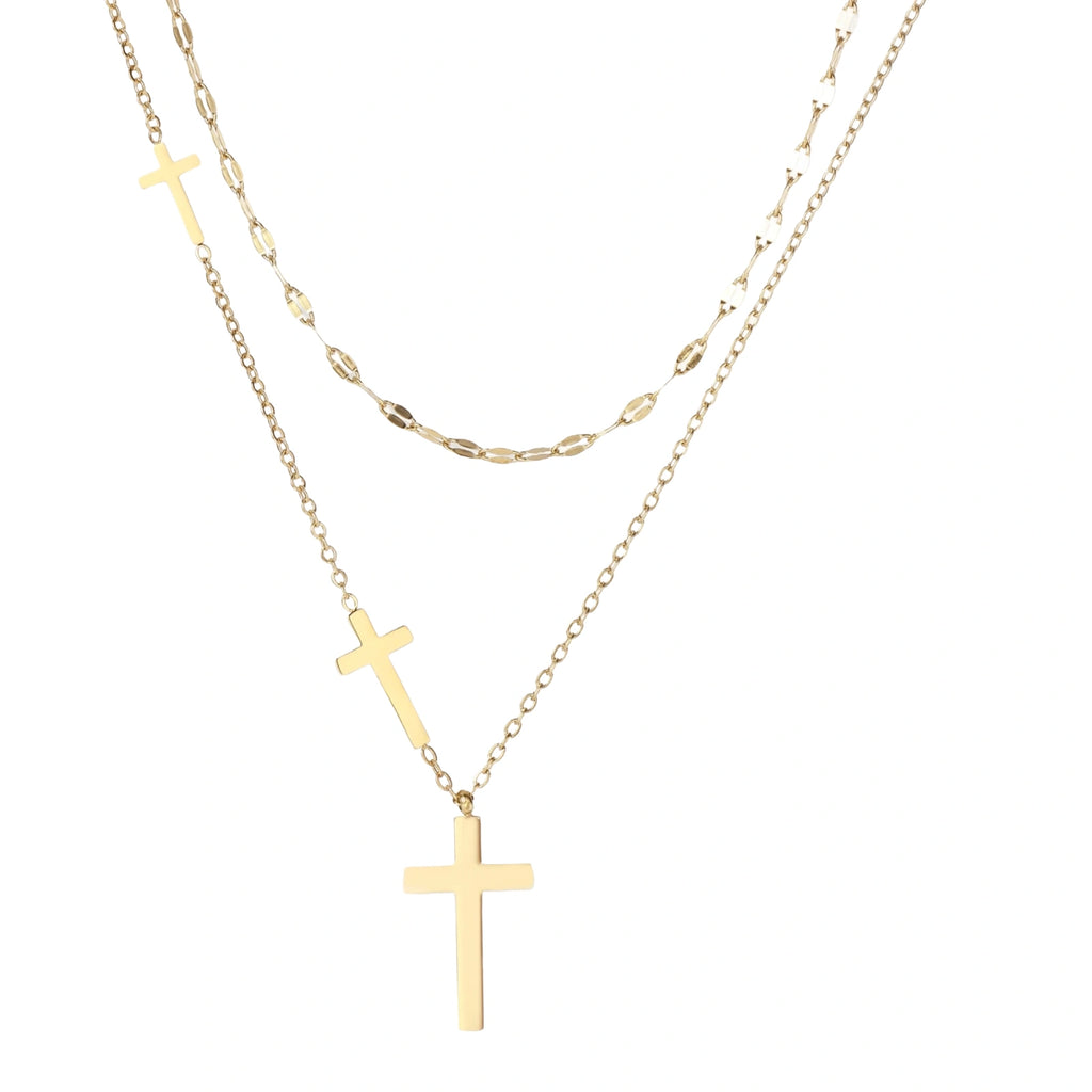 Three-layered gold necklace set with graduated cross pendants in mixed chain styles on white background.