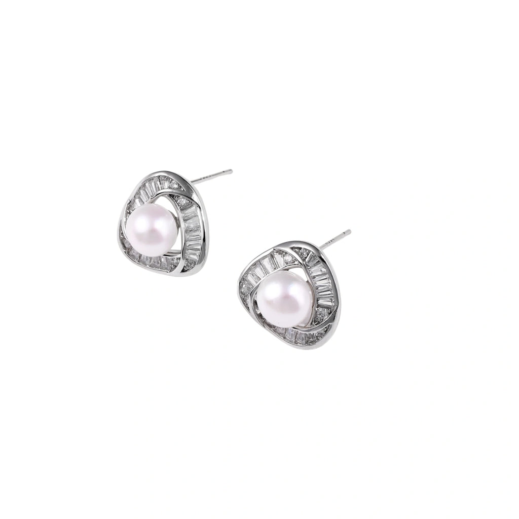Triangular white gold plated stud earrings with central freshwater pearl and baguette-cut stones on white background