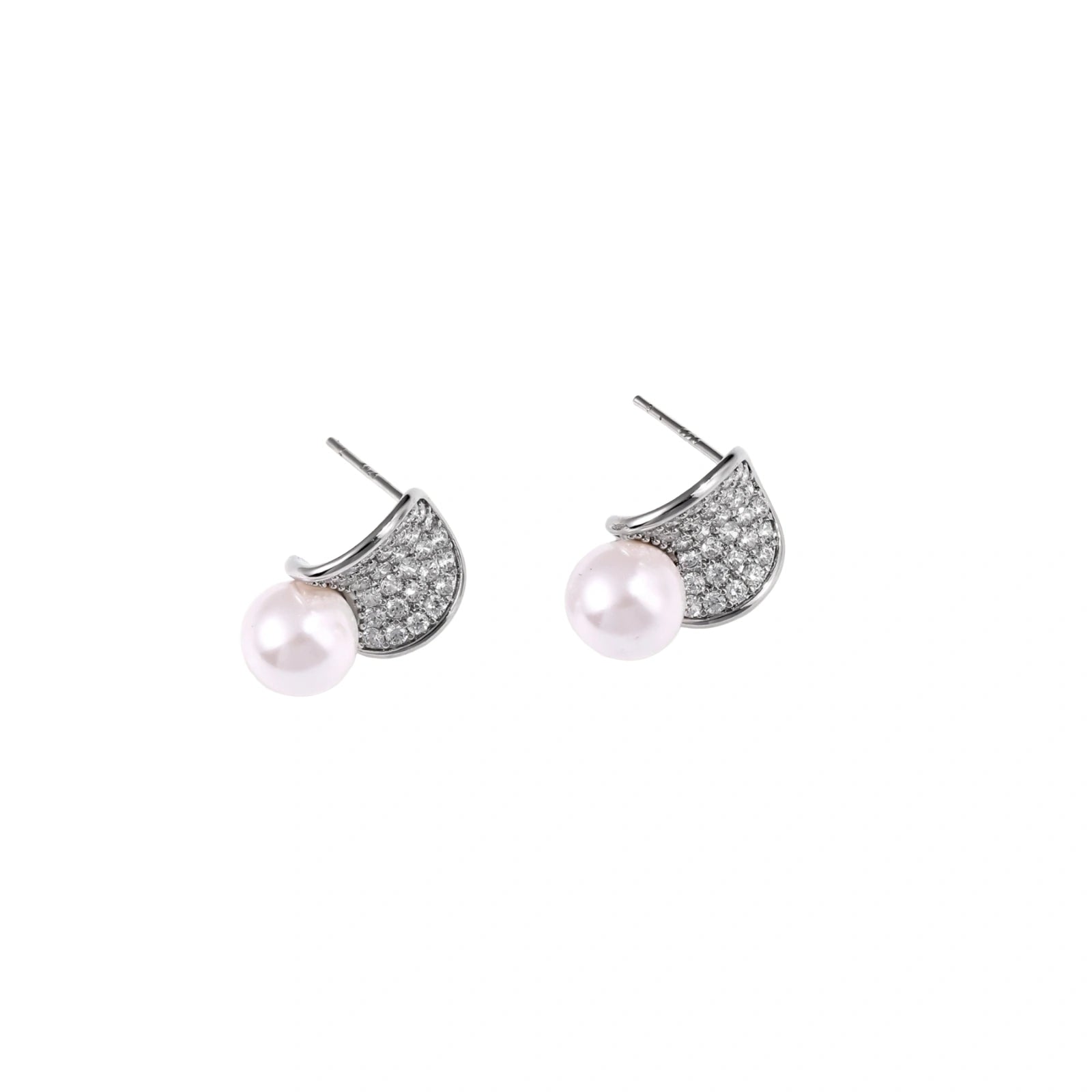 Curved pavé diamond studs in white gold-plated brass cradle lustrous freshwater pearls against cream background