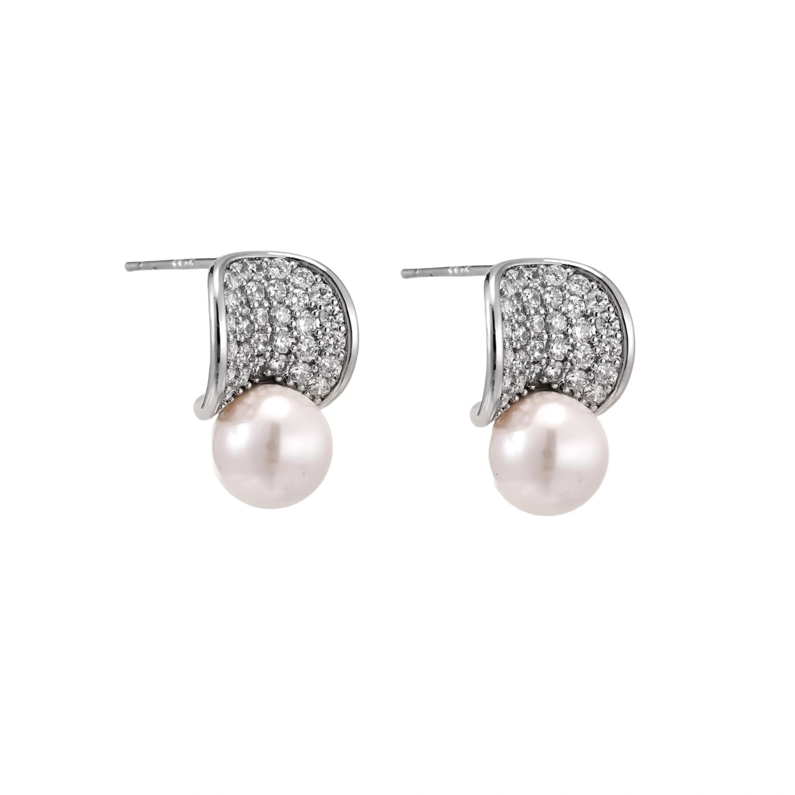 Curved pavé diamond studs in white gold-plated brass cradle lustrous freshwater pearls against cream background