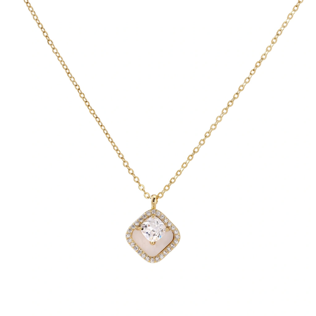 Gold quatrefoil pendant with crystal center on iridescent mother-of-pearl base, adjustable gold chain on cream background