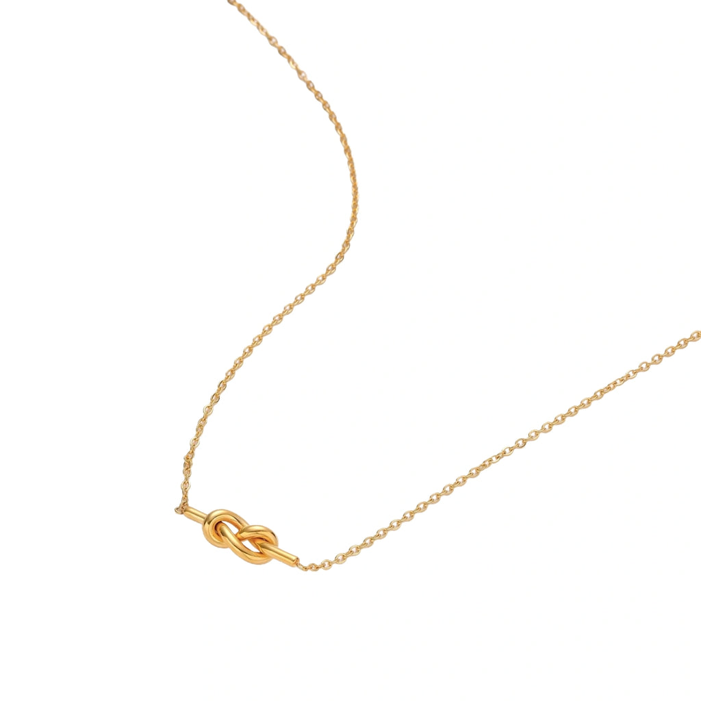 Dainty 18K gold plated necklace with infinity knot pendant on delicate chain against white background