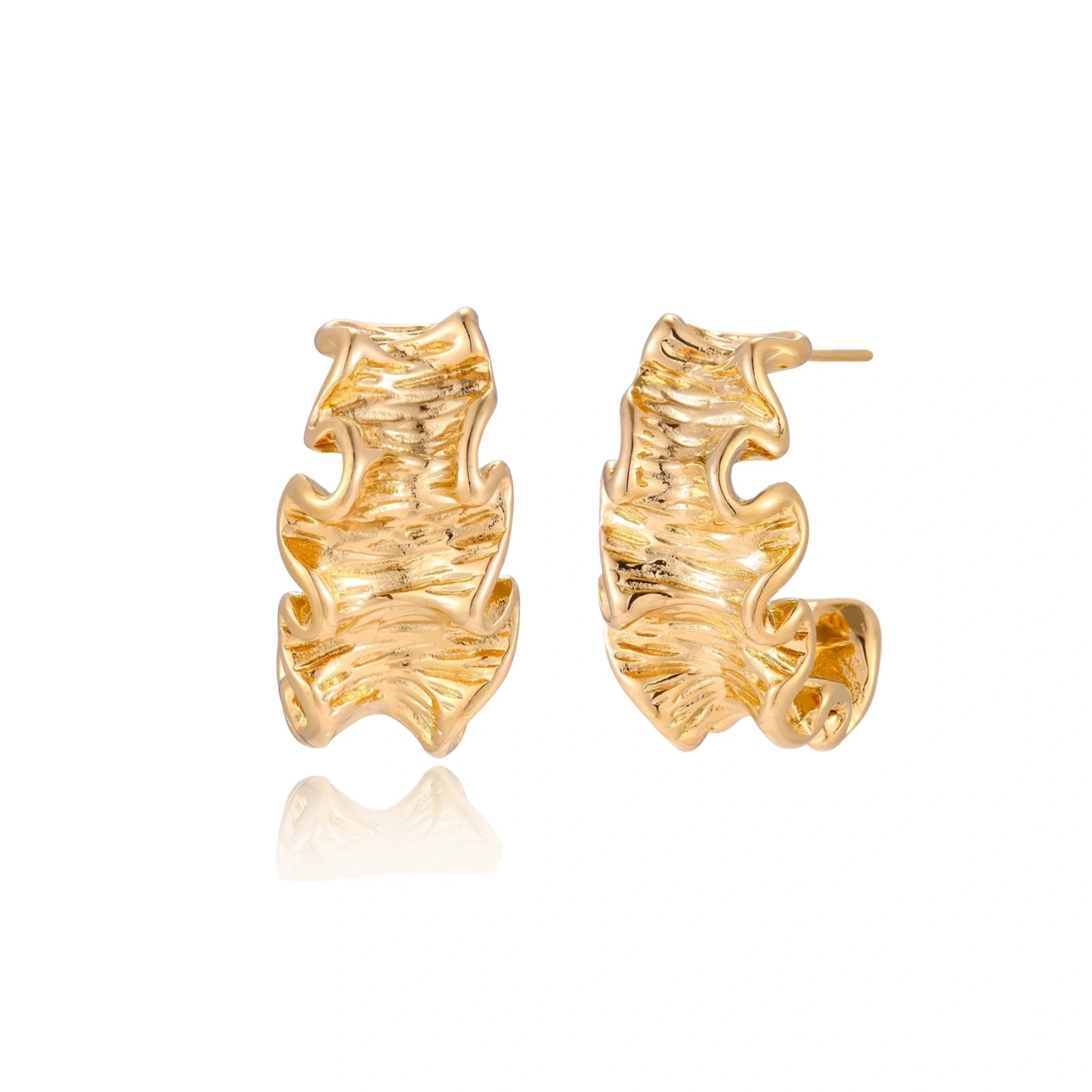 Pair of gold huggie hoops with sculpted wave texture and dimensional ripples on neutral background.