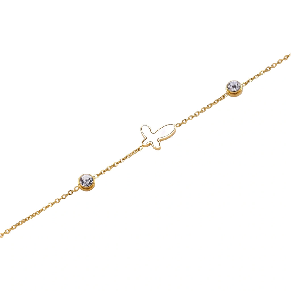 Gold chain bracelet with white mother of pearl butterfly pendant and two bezel-set crystals on cream background