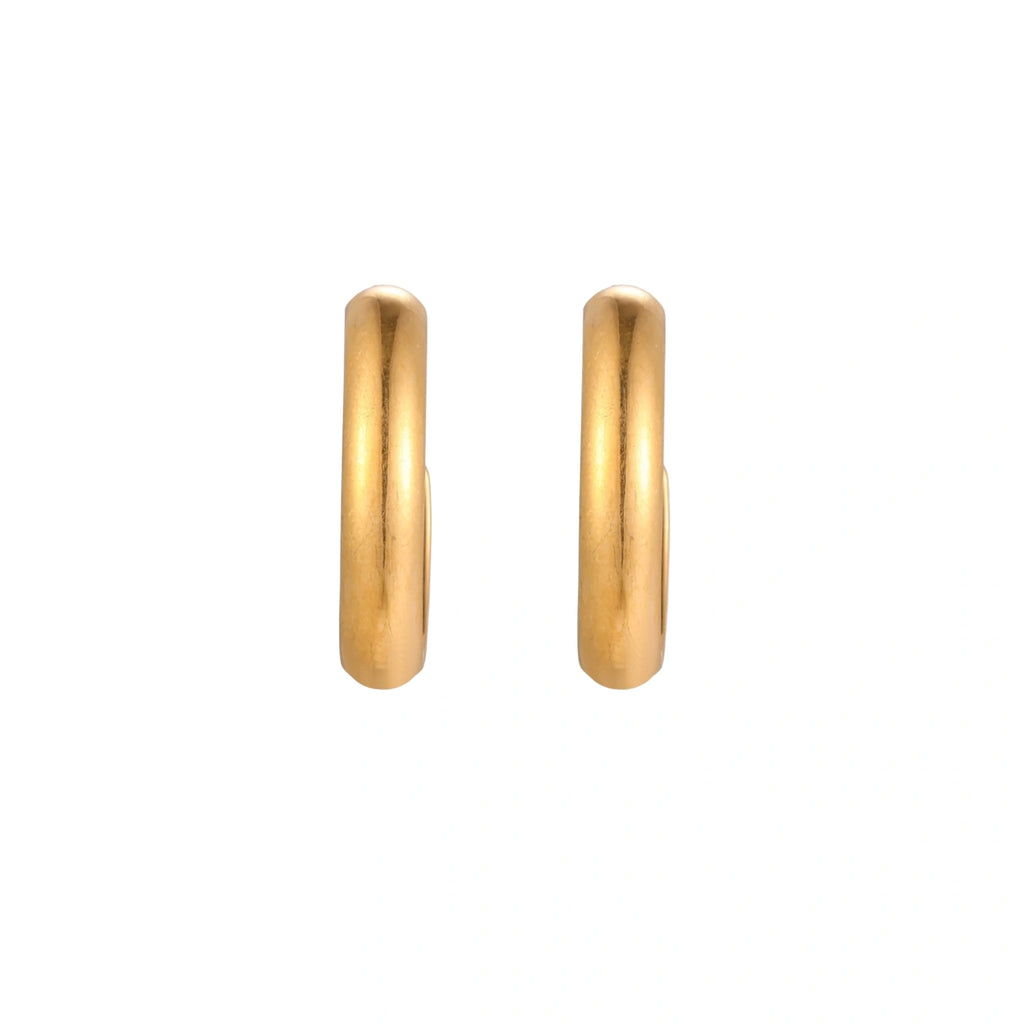 Chunky tubular hoop earrings in warm 14K gold-plated finish with smooth polished surface on cream background.