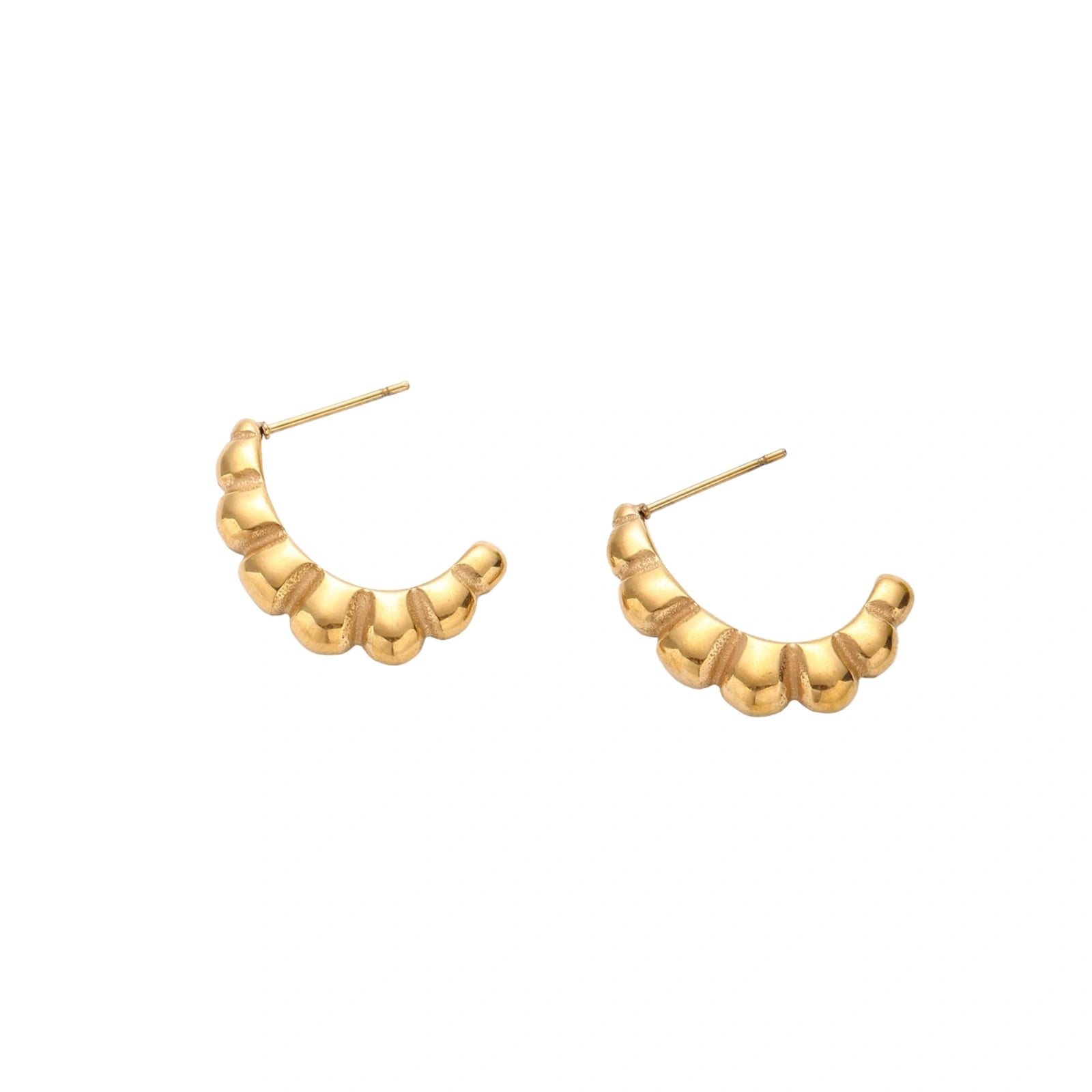 Gold-plated chunky hoop earrings with ridged bubble texture on cream background