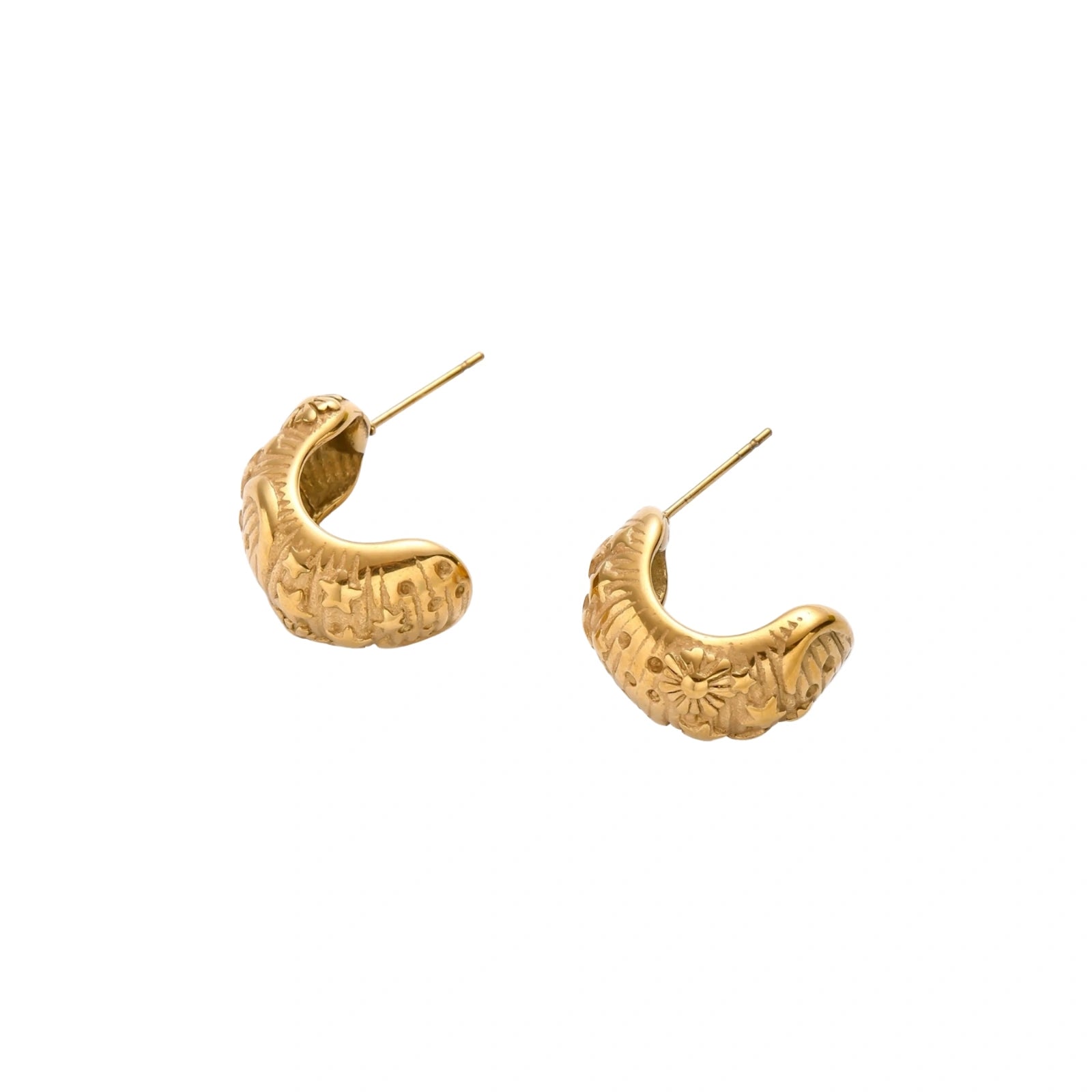 Wide gold hoop earrings with embossed stars and sun motifs on cream background, showing dimensional relief details.