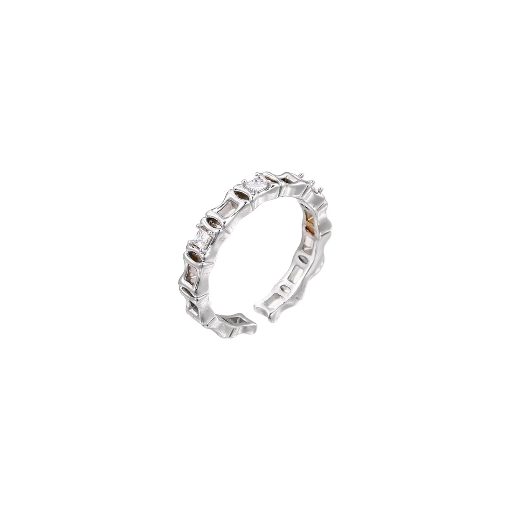 White gold plated ring with architectural lattice design and zirconia accents on cream background