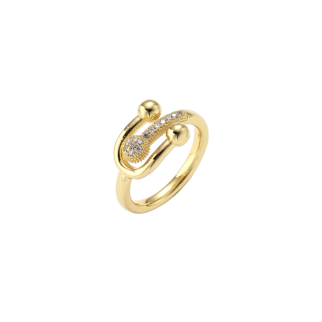 Gold-plated brass ring with safety pin design featuring pavé cubic zirconia stones and dual sphere ends