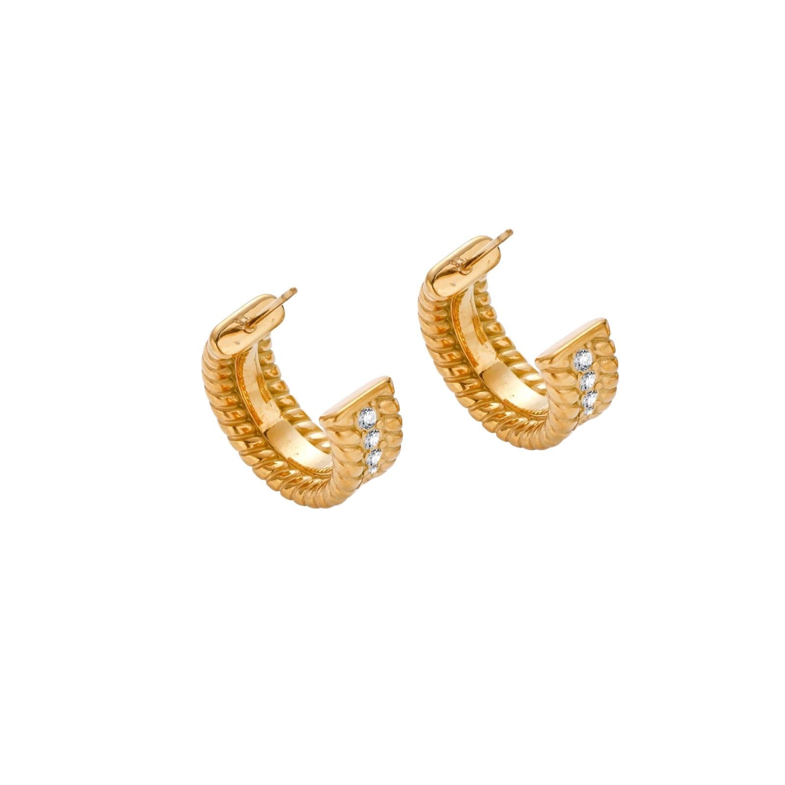 Textured gold huggie hoop earrings with raised ribbed rows creating dimensional sculptural design on cream background