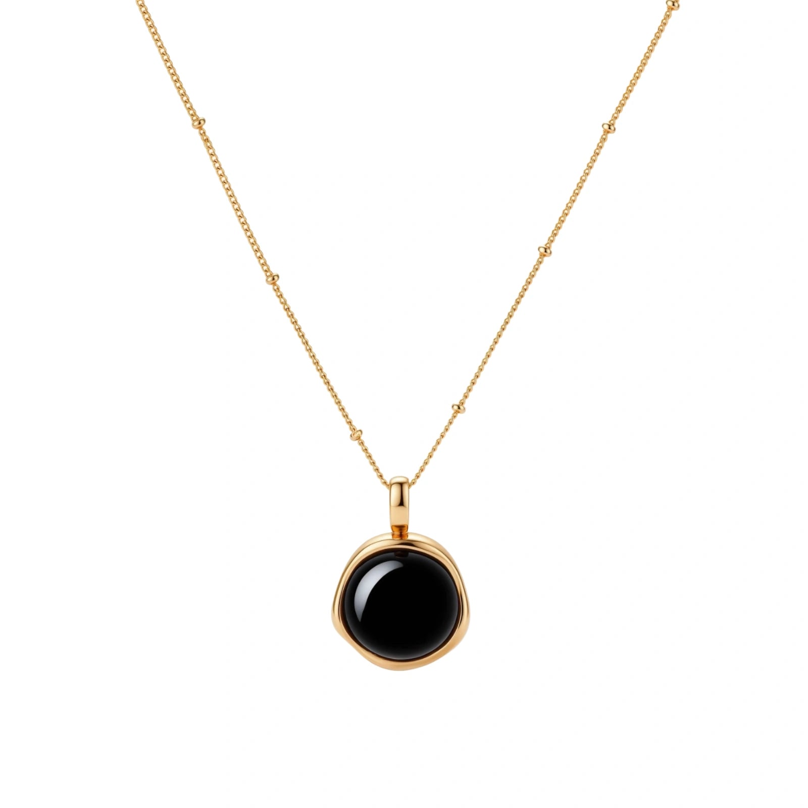 Circular black agate pendant on gold-plated sterling silver chain against cream background, showing modern minimalist design.