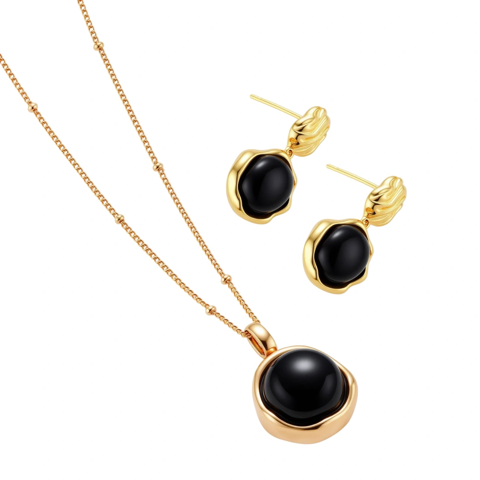 Circular black agate pendant on gold-plated sterling silver chain against cream background, showing modern minimalist design.