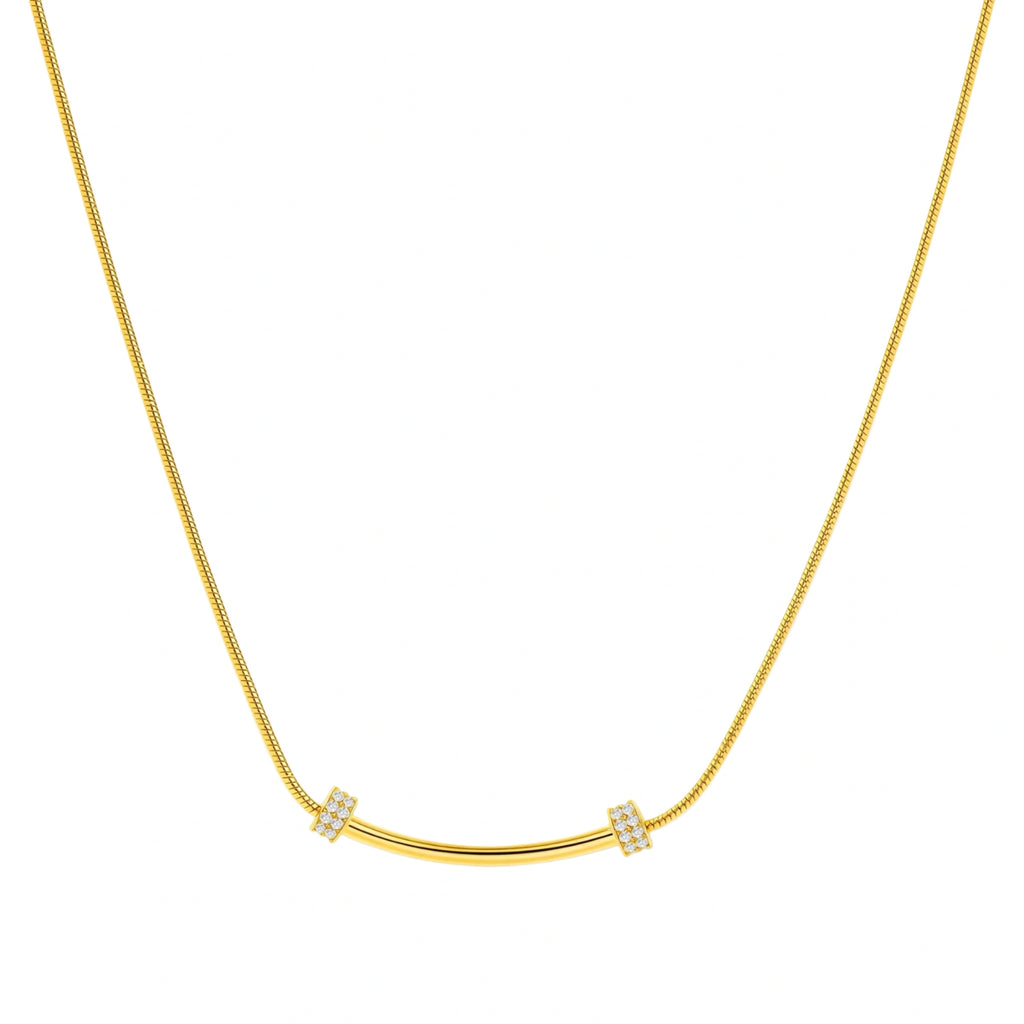 Delicate gold-plated necklace with curved bar pendant and crystal accents on snake chain against cream background.