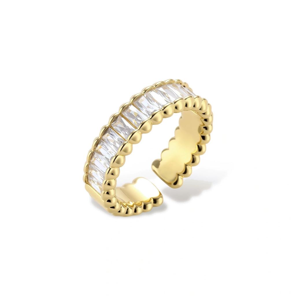 Adjustable gold-plated ring with rectangular cubic zirconia stones in eternity band style on neutral background.