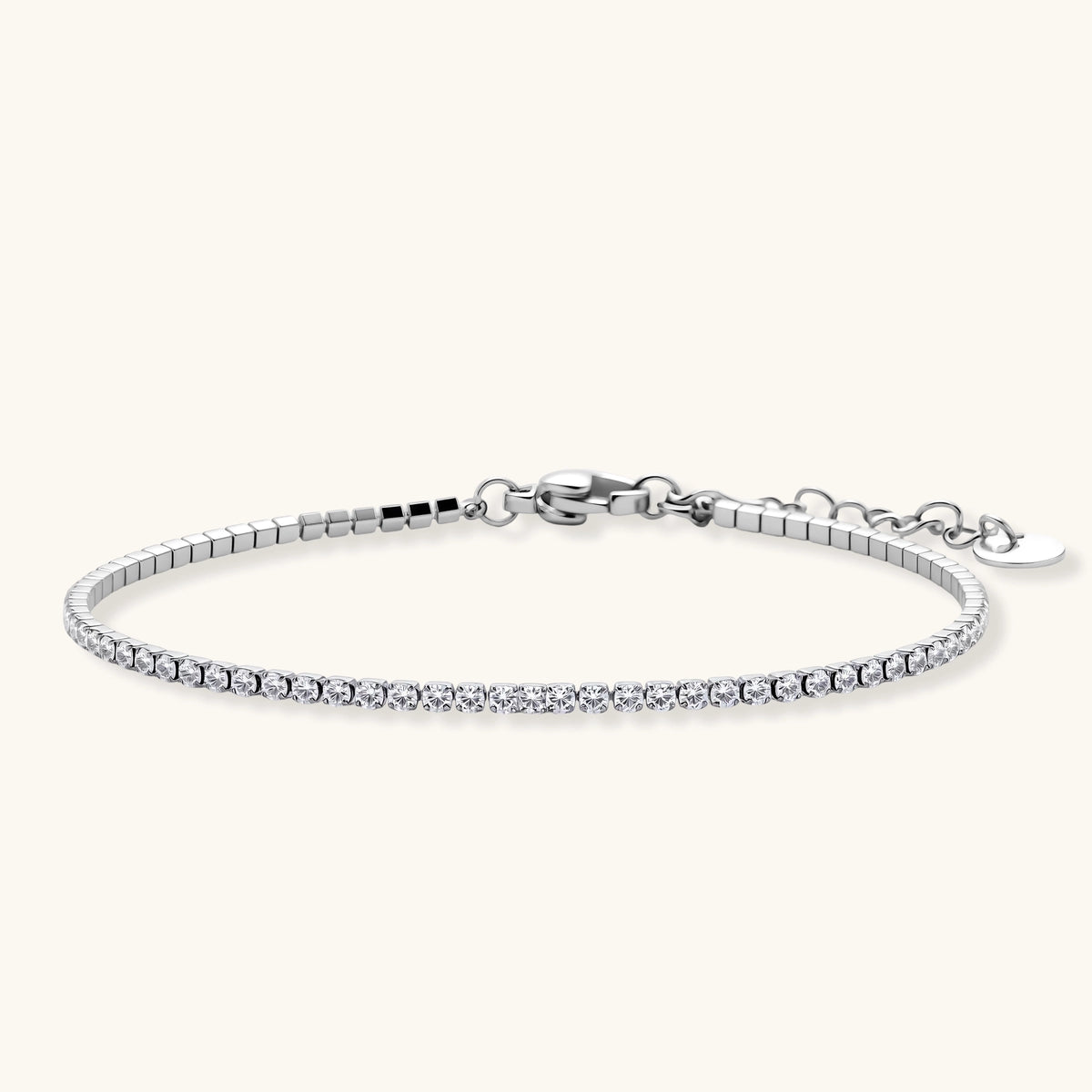 Silver stainless steel tennis bracelet with a single row of clear round zircon stones, lobster clasp, and adjustable extender chain.