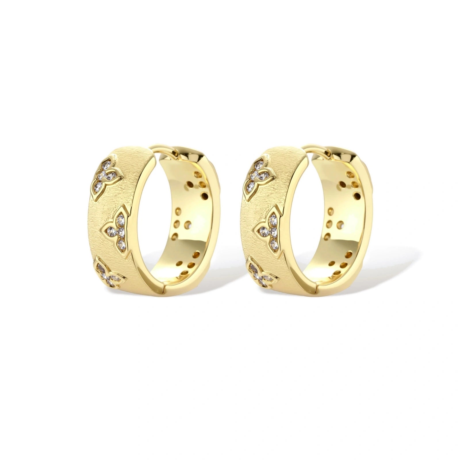 Gold-plated hoop earrings with textured surface and raised floral motifs set with clear zirconia stones on cream background.