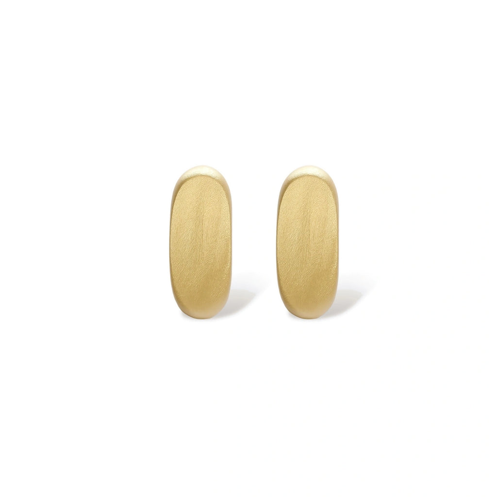 Small gold huggie earrings with matte finish, 14mm diameter, shown against cream background for everyday elegance.