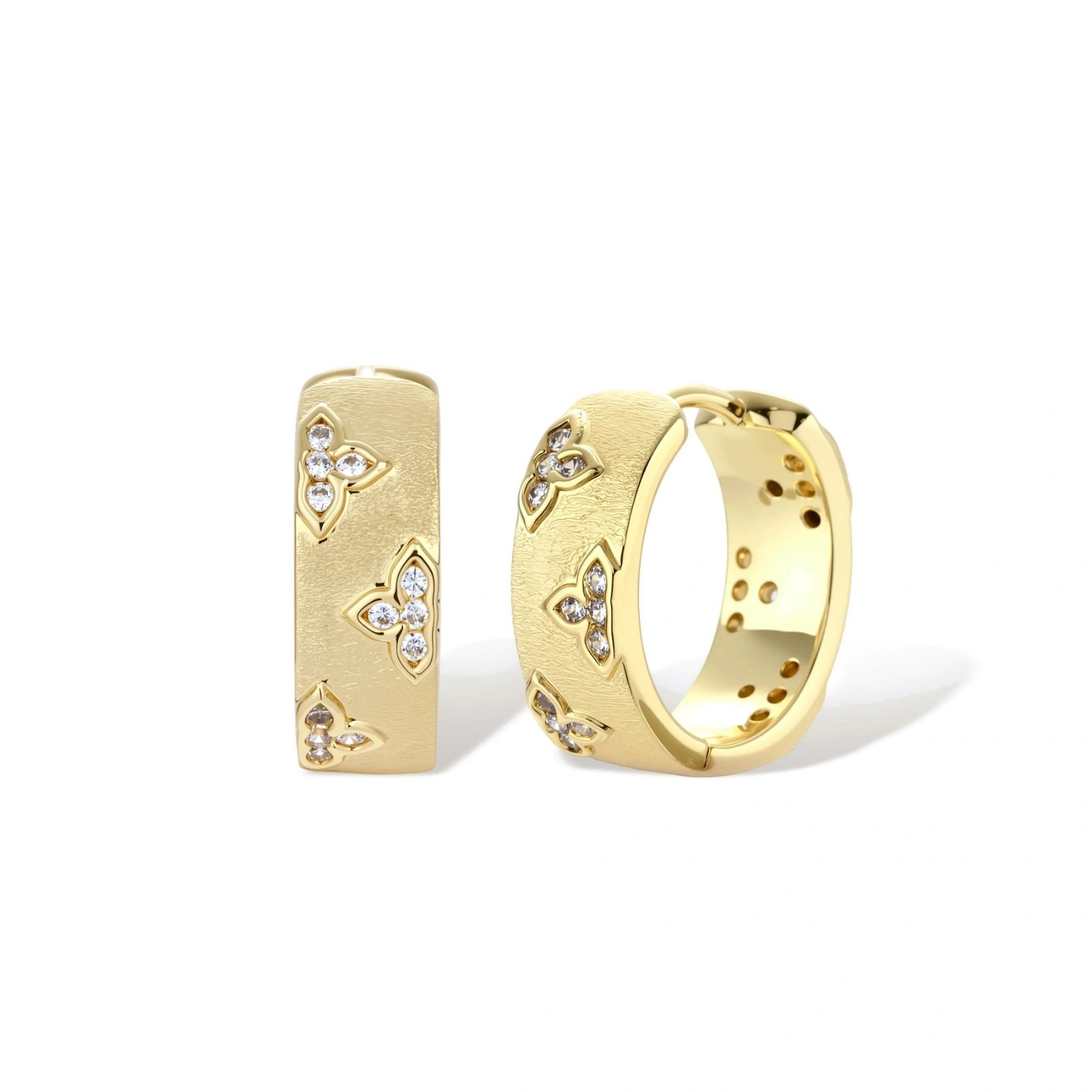 Gold-plated hoop earrings with textured surface and raised floral motifs set with clear zirconia stones on cream background.